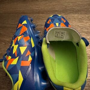 Youth Blue Soccer Cleats with Neon Green Lining and Orange Accents
